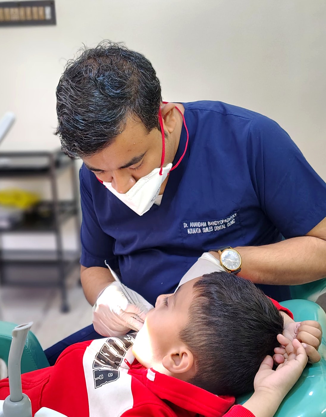 Dr. Anandam Bandyopadhyay gently treating a young child at Kolkata Smiles Dental Clinic, Dum Dum, Kolkata